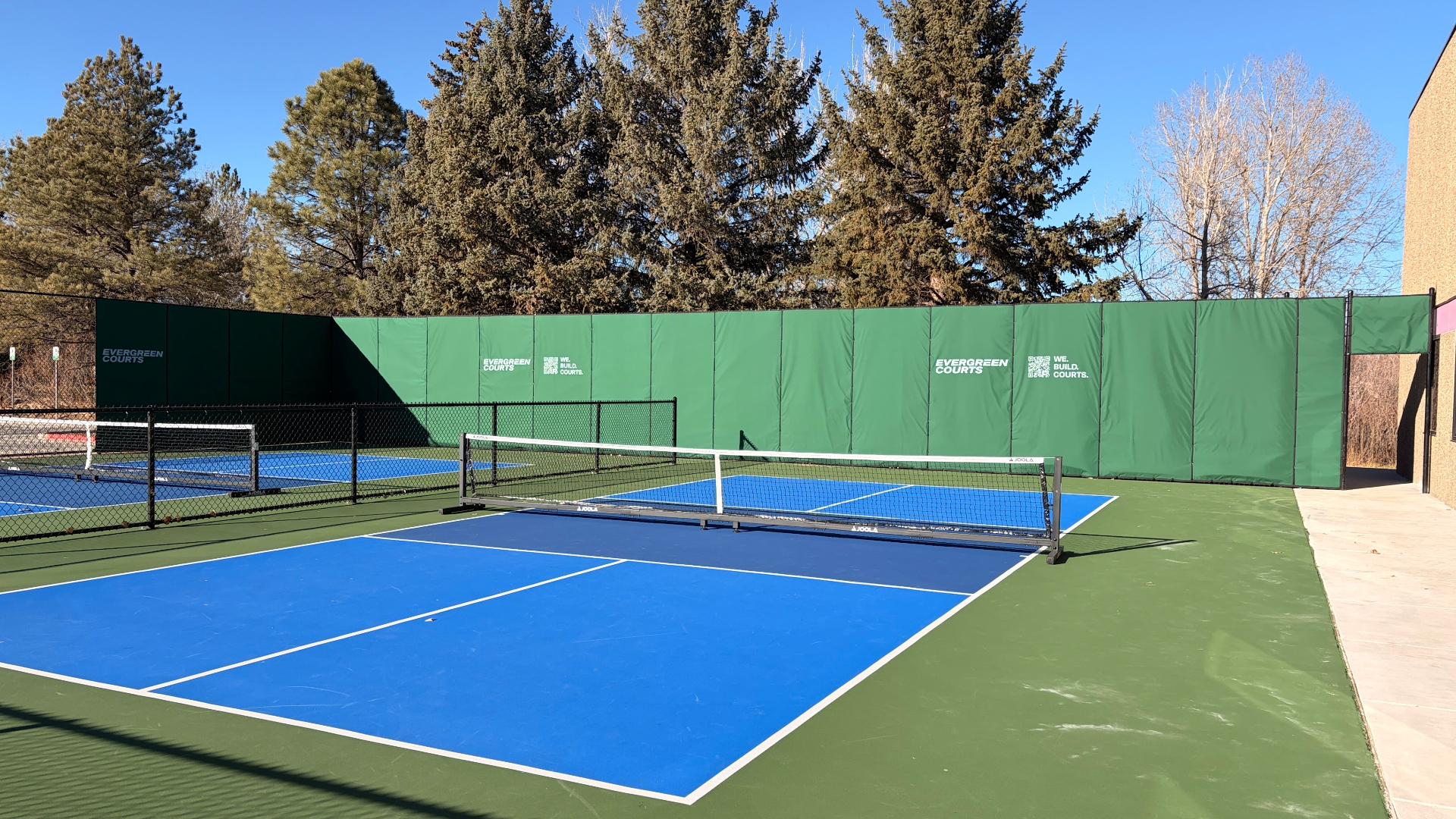 SLN/CR NanoBaffle outdoor sound barrier panels mounted on pickleball court fence